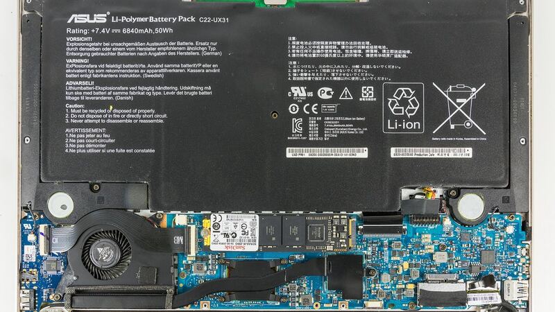 Inside an ASUS Zenbook ultrabook with the bottom cover off, showing the large flat battery (older Zenbook model)