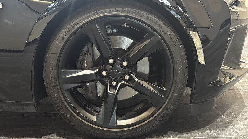 Black sixth-generation Chevrolet Camaro SS front wheel with the brake caliper visible behind the spokes