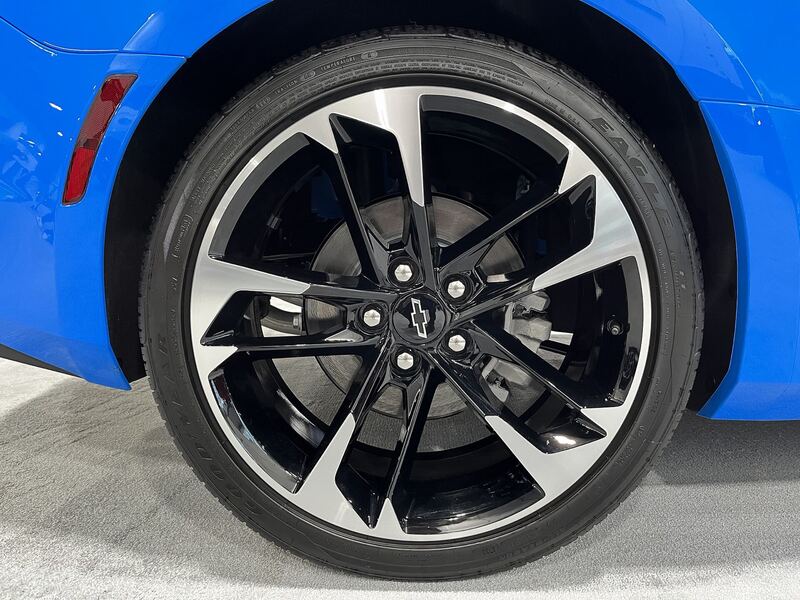 Blue Chevrolet Camaro wheel and low-profile 20-inch tire, close-up