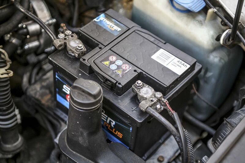 12-volt car battery with corroded terminals installed in an engine bay (similar vehicle)