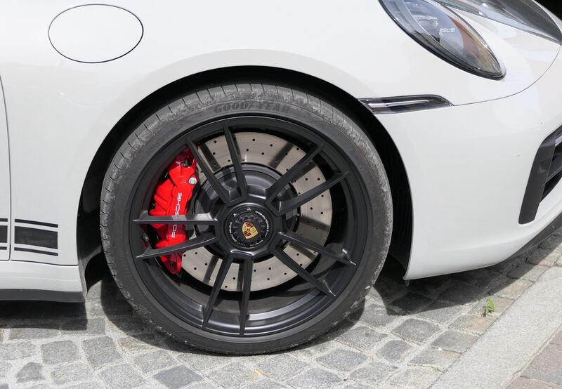 Big red performance brake caliper and drilled rotor behind a black wheel (similar performance car)