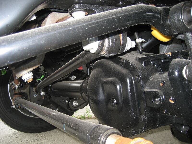 Underside view of a Ford Super Duty solid front axle with track bar, tie rod and steering linkage
