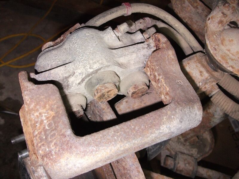Heavily rusted brake caliper bracket on a 4x4 during a brake job (similar vehicle)