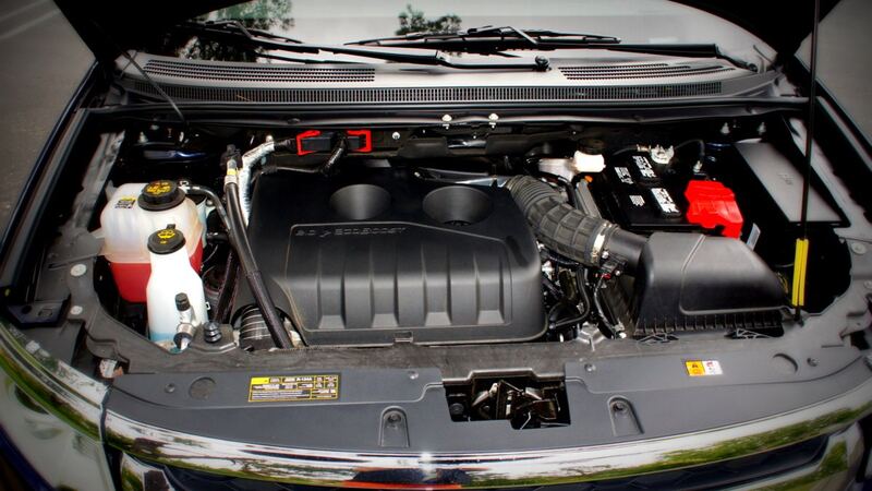 Open engine bay of a Ford Edge showing the EcoBoost engine cover and coolant reservoir