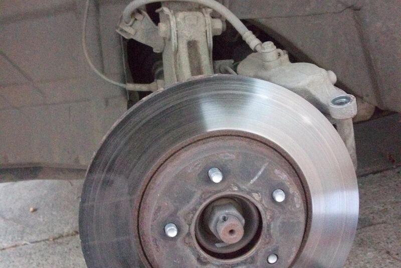 Car brake rotor on the hub with the wheel and caliper removed during a brake job (similar vehicle)