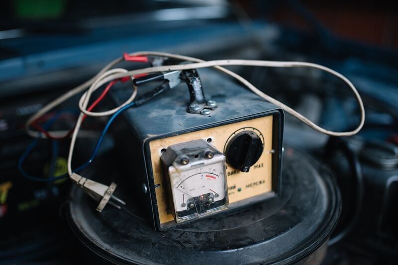 Old-style battery charger with a gauge connected in an engine bay (similar vehicle)