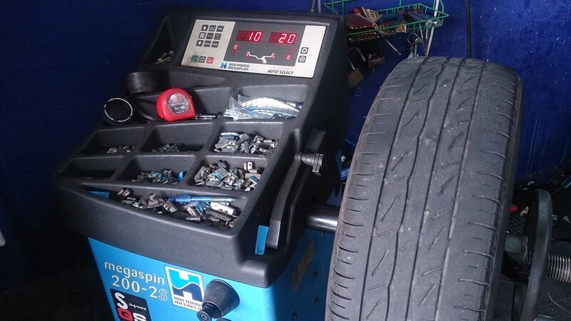 Tire mounted on a wheel balancing machine in a shop, similar vehicle