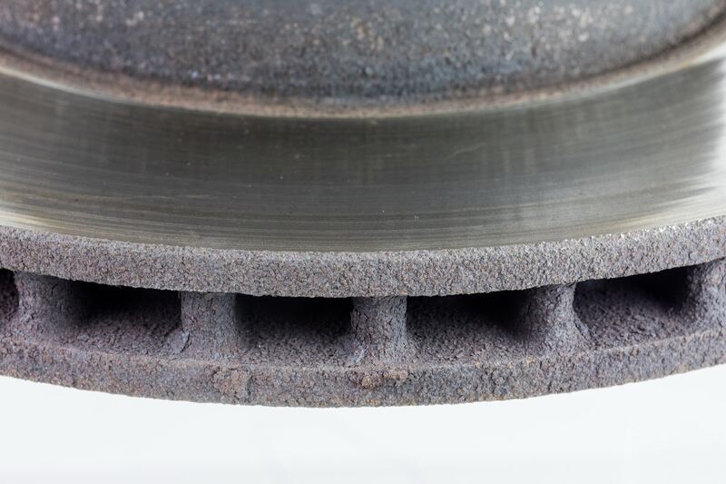 Close-up of a worn, rusty ventilated brake rotor edge with a deep wear lip (similar vehicle part)