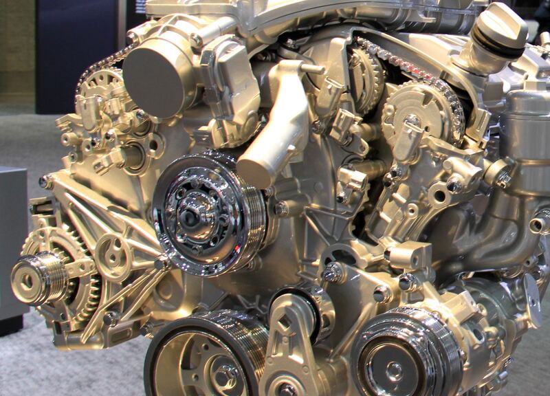 GMC gasoline engine on display showing the timing chain, cam gears and front pulleys