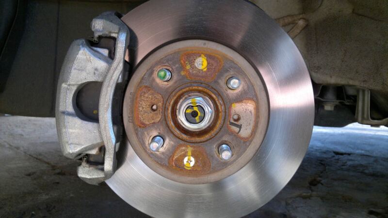 Front brake caliper and rotor on a small Honda with the wheel removed