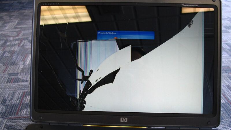 HP laptop with a badly shattered screen showing dark cracks across the display (older HP model)