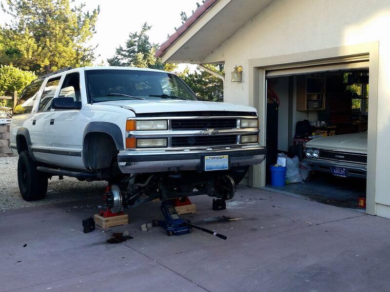 SUV on jack stands with both front wheels off and new brake rotors visible, similar to a Santa Fe brake job