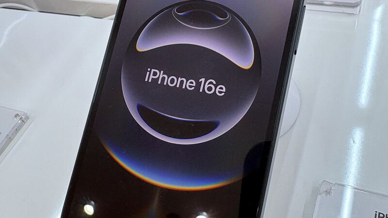 Black iPhone 16e on a store display stand