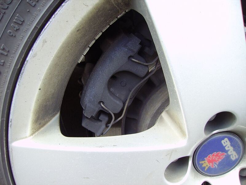 Rear disc brake rotor and caliper seen through the spokes of an alloy wheel (similar vehicle)