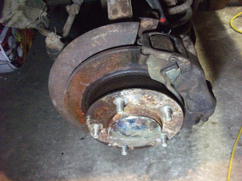 Rusty brake rotor and caliper with the wheel removed during a brake job (similar vehicle)