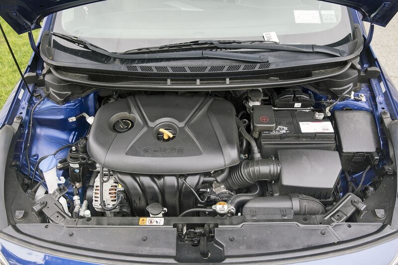 Kia Forte engine bay with the hood open, battery and 2.0-liter engine visible
