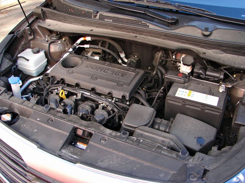 Kia Sportage engine bay with the hood open, a similar Kia setup