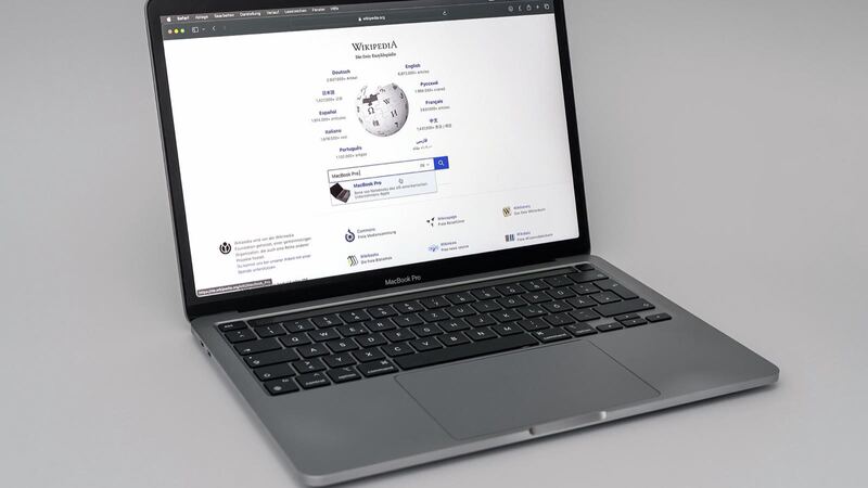 MacBook Pro 13-inch M1 (2020) in Space Gray, open on a plain gray background