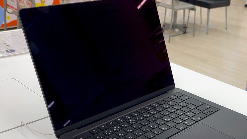 MacBook Pro 14-inch M3 in Space Gray, open on a white store display table