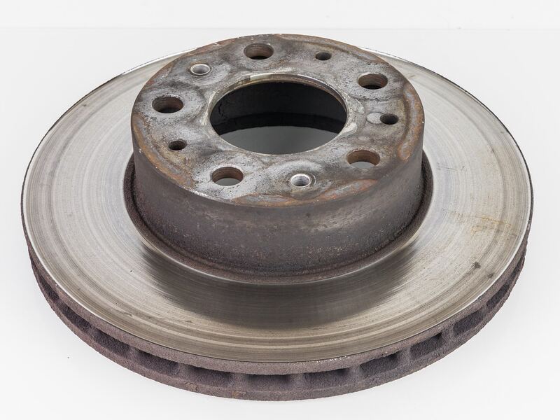 Worn, rusty brake rotor removed from a work van, showing a scored braking surface