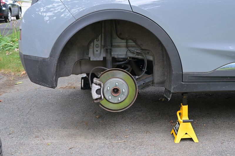 SUV on a jack stand with the rear wheel off, showing the brake rotor and caliper (similar vehicle)