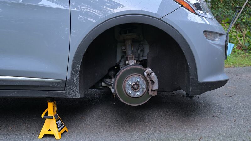 Car with the front wheel off, showing the brake rotor and caliper