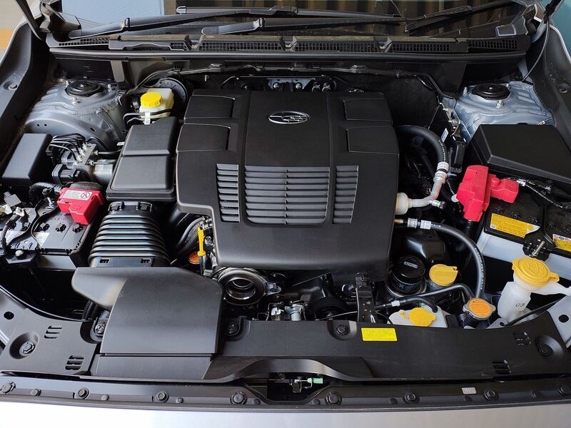 Subaru Crosstrek with the hood open showing the 2.0-liter boxer engine and the battery area