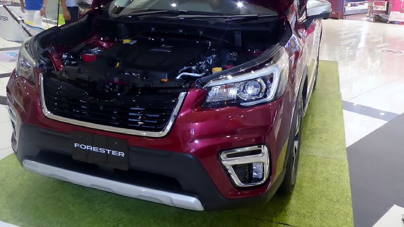 Red current-generation Subaru Forester parked with the hood open
