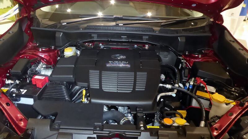 Engine bay of a red current-generation Subaru Forester with the hood open