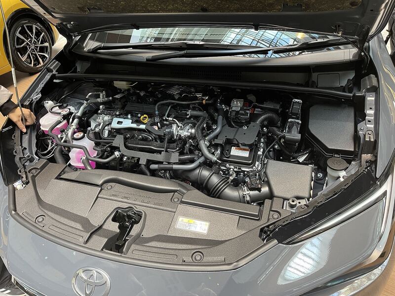 Engine bay of a fifth-generation Toyota Prius with the hood open, showing the 2.0-liter hybrid engine and fuse box