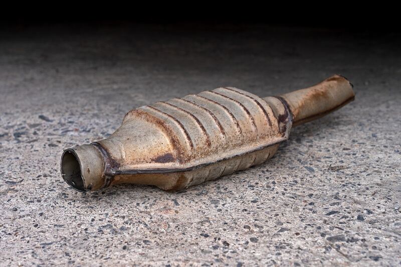 A cut-out catalytic converter lying on pavement